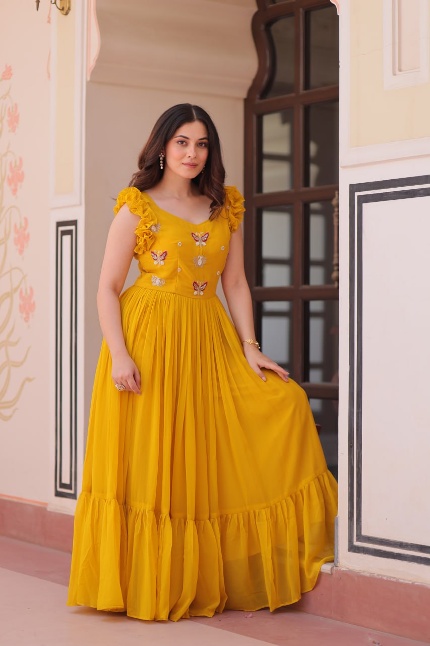 Lavi 7-meter flared designer gown in faux blooming fabric with sequin & bead embroidery, V-neck & frill shoulders – perfect for weddings & parties.